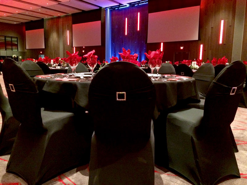 Chairs wrapped in black cloth at a dinner table